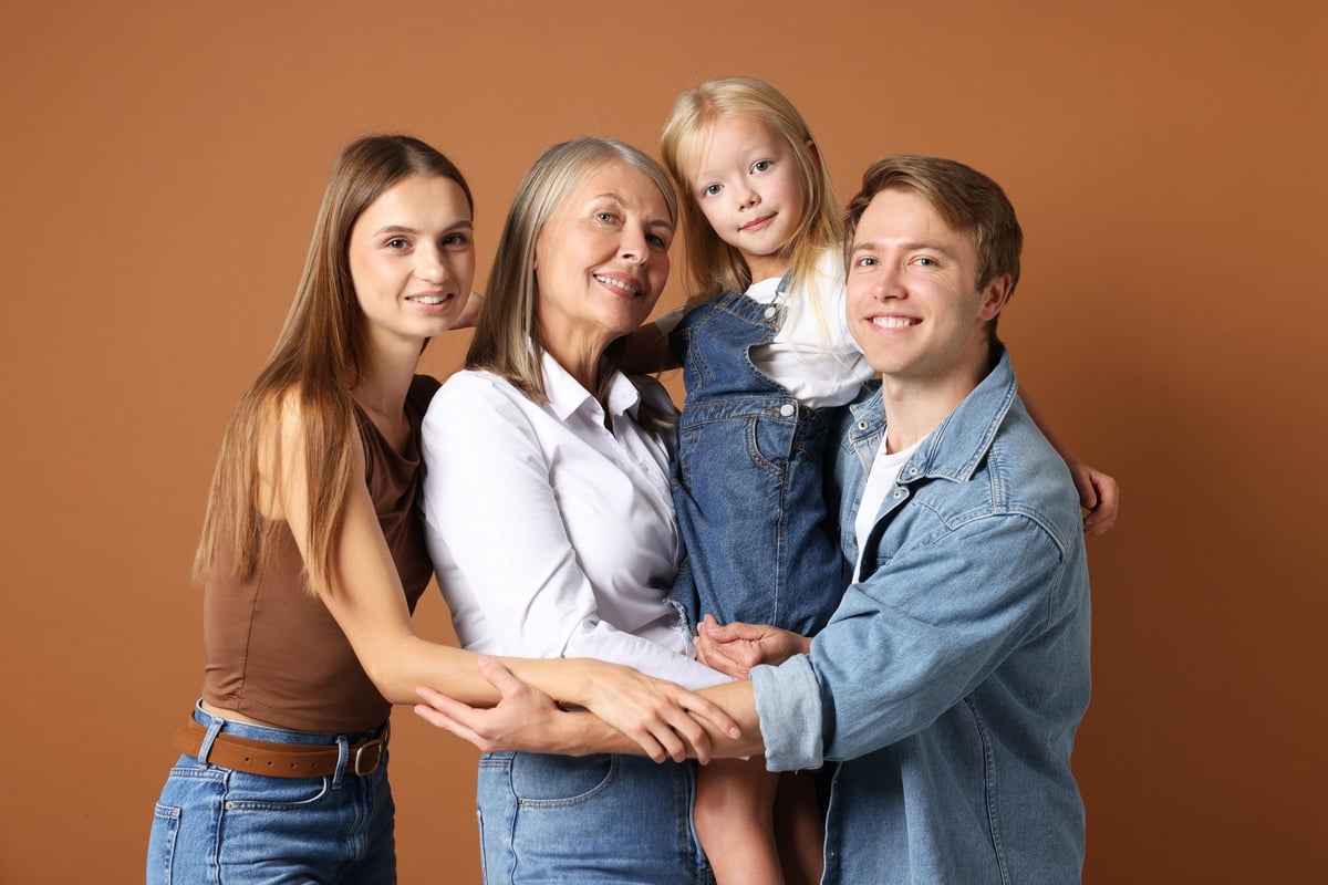 Portrait of senior woman with son and his family on brown background
